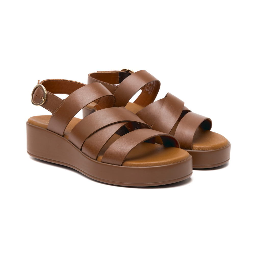 Sandalia de plataforma color tan con correas cruzadas y hebilla dorada para mujer.