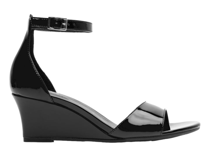 Sandalia Flexi color negro brillante con tacón de cuña y correa ajustable al tobillo para mujer.