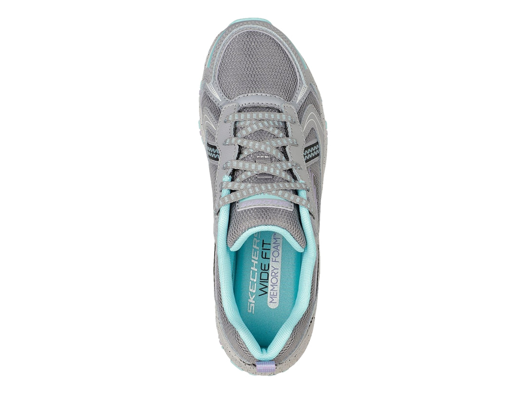 Tenis deportivos Skechers color gris con detalles en azul claro, diseñados para actividades al aire libre.