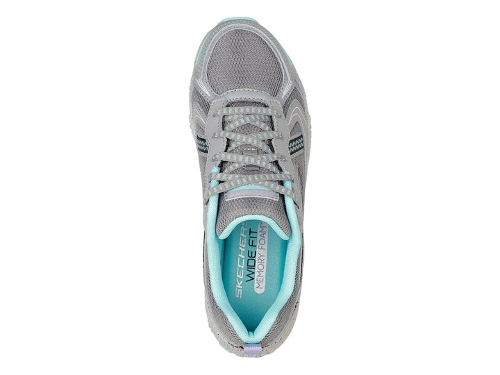 Tenis deportivos Skechers color gris con detalles en azul claro, diseñados para actividades al aire libre.