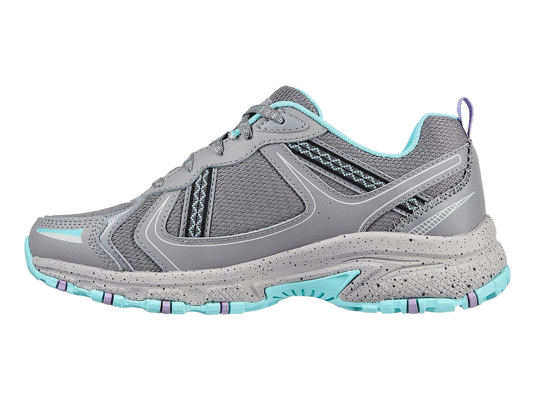 Tenis deportivos Skechers color gris con detalles en azul claro, diseñados para actividades al aire libre.