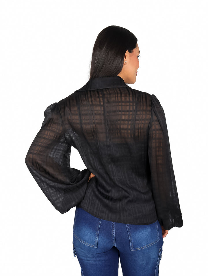 Mujer modelando una blusa negra de manga larga con botones y cuello.