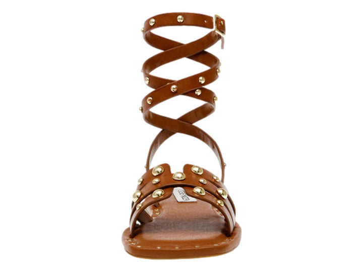 Sandalia plana color cognac de Steve Madden con tiras envolventes al tobillo y detalles de tachuelas doradas.