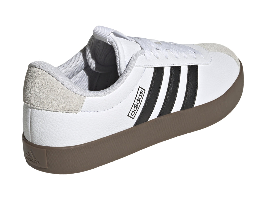 Tenis Adidas VL Court 3.0 blancos con tres franjas negras, detalles grises y suela color café.
