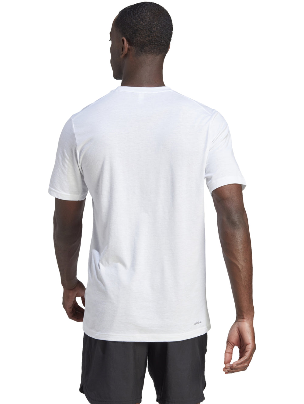 Hombre vistiendo una camiseta deportiva blanca de manga corta con logo negro de Adidas en el pecho.