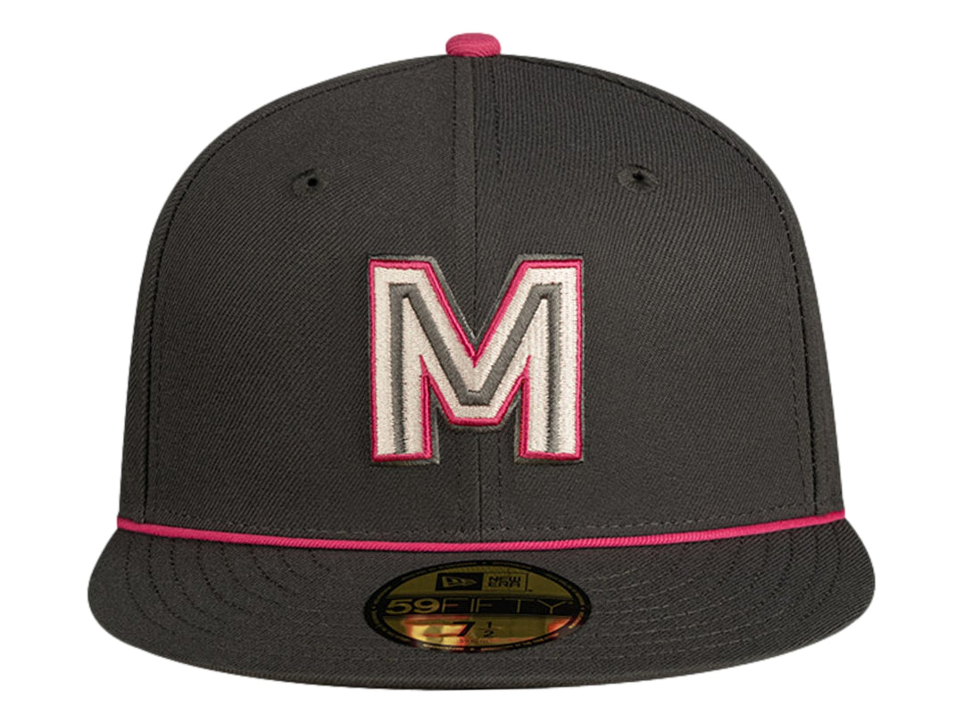 Gorra de béisbol New Era color gris oscuro con detalles en rosa y letra M bordada al frente.