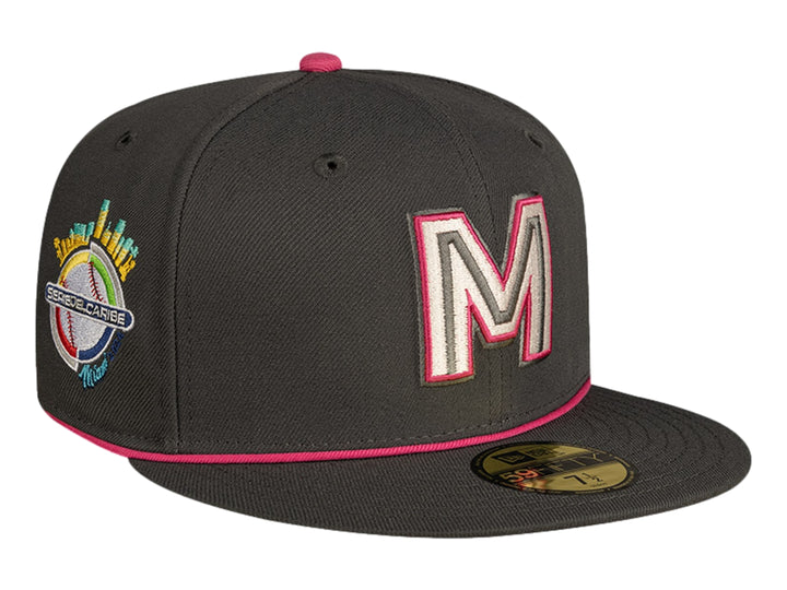 Gorra de béisbol New Era color gris oscuro con detalles en rosa y letra M bordada al frente.