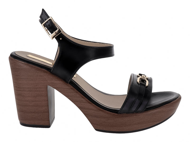 Sandalia negra de plataforma con tacón grueso color madera y detalle de hebilla dorada.