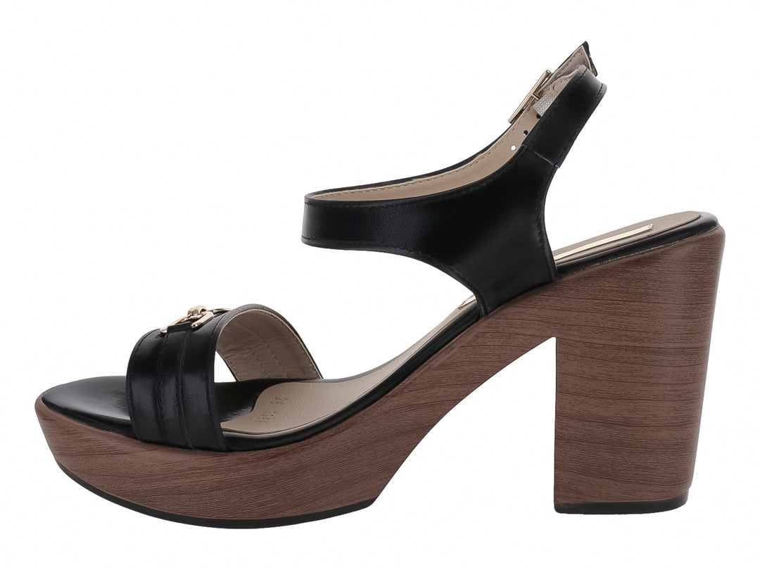 Sandalia negra de plataforma con tacón grueso color madera y detalle de hebilla dorada.