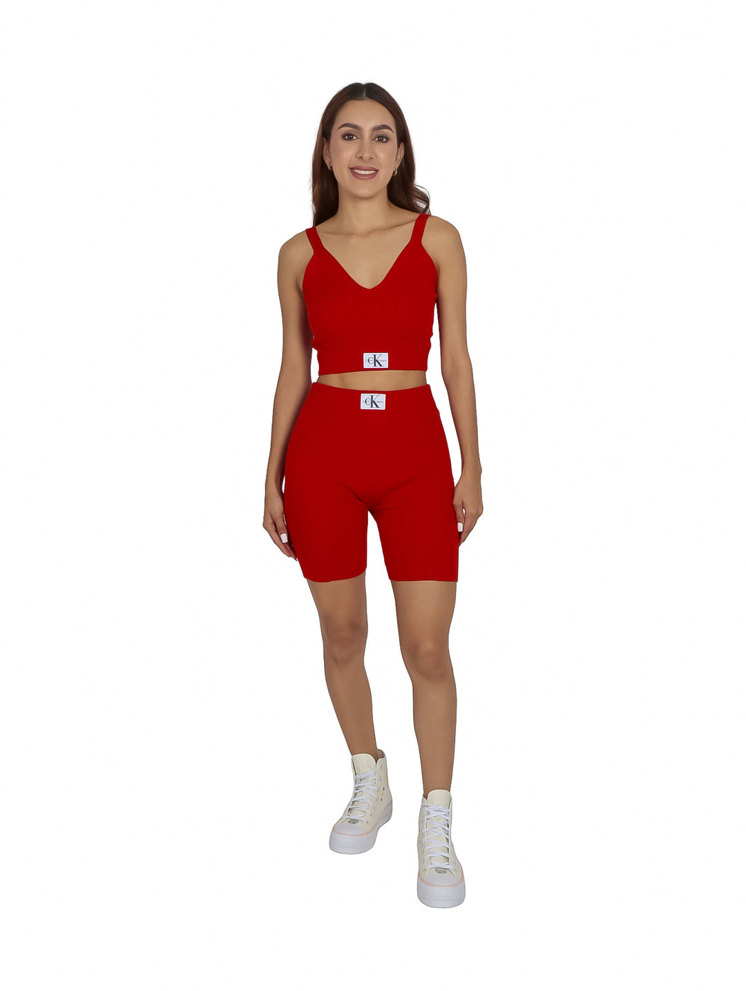 Mujer vistiendo un bralette tejido color rojo intenso de Calvin Klein con etiqueta blanca.