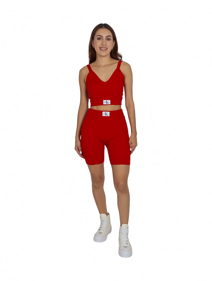 Mujer vistiendo un bralette tejido color rojo intenso de Calvin Klein con etiqueta blanca.
