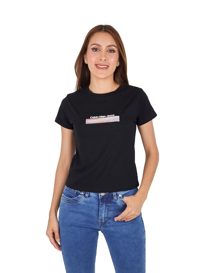 Mujer vistiendo una camiseta negra ajustada de Calvin Klein con un gráfico rectangular en el pecho.