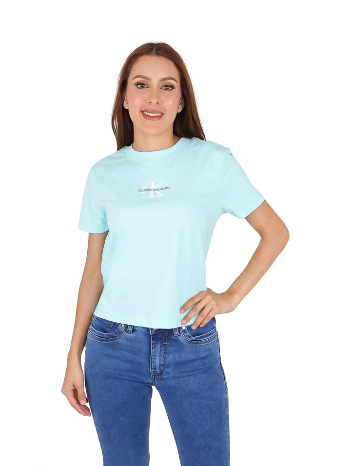 Mujer vistiendo camiseta azul claro de manga corta Calvin Klein y jeans azules.