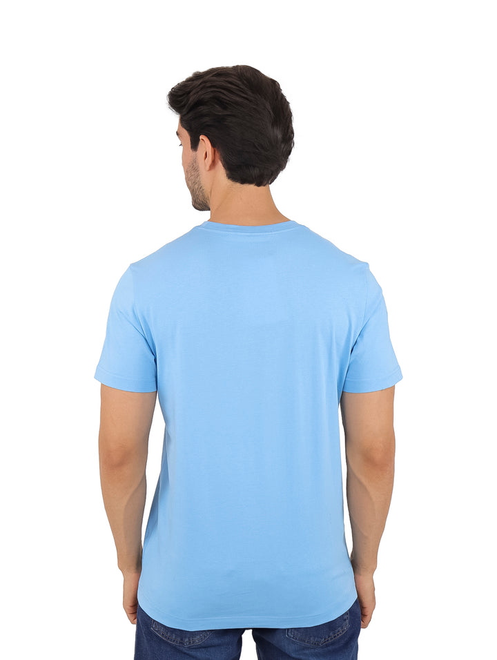 Hombre vistiendo una camiseta de manga corta color azul claro con logotipo de Calvin Klein Jeans en el pecho.