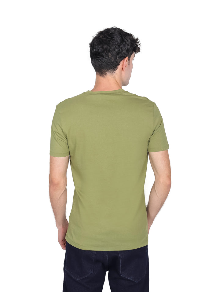 Hombre vistiendo camiseta de manga corta color verde oscuro con logotipo de Calvin Klein Jeans en el pecho.