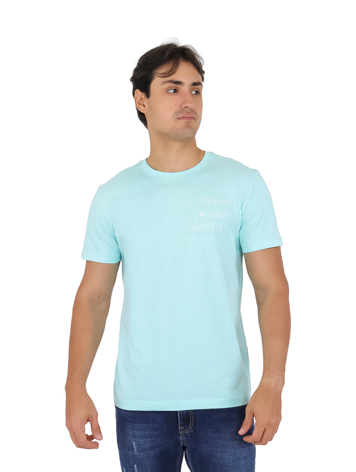 Hombre vistiendo una camiseta de manga corta color azul claro con logo difuminado en el pecho.