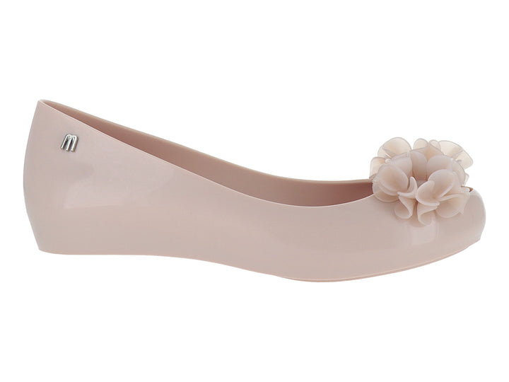 Zapato plano Melissa color rosa con detalle de flor en la punta y acabado brillante.