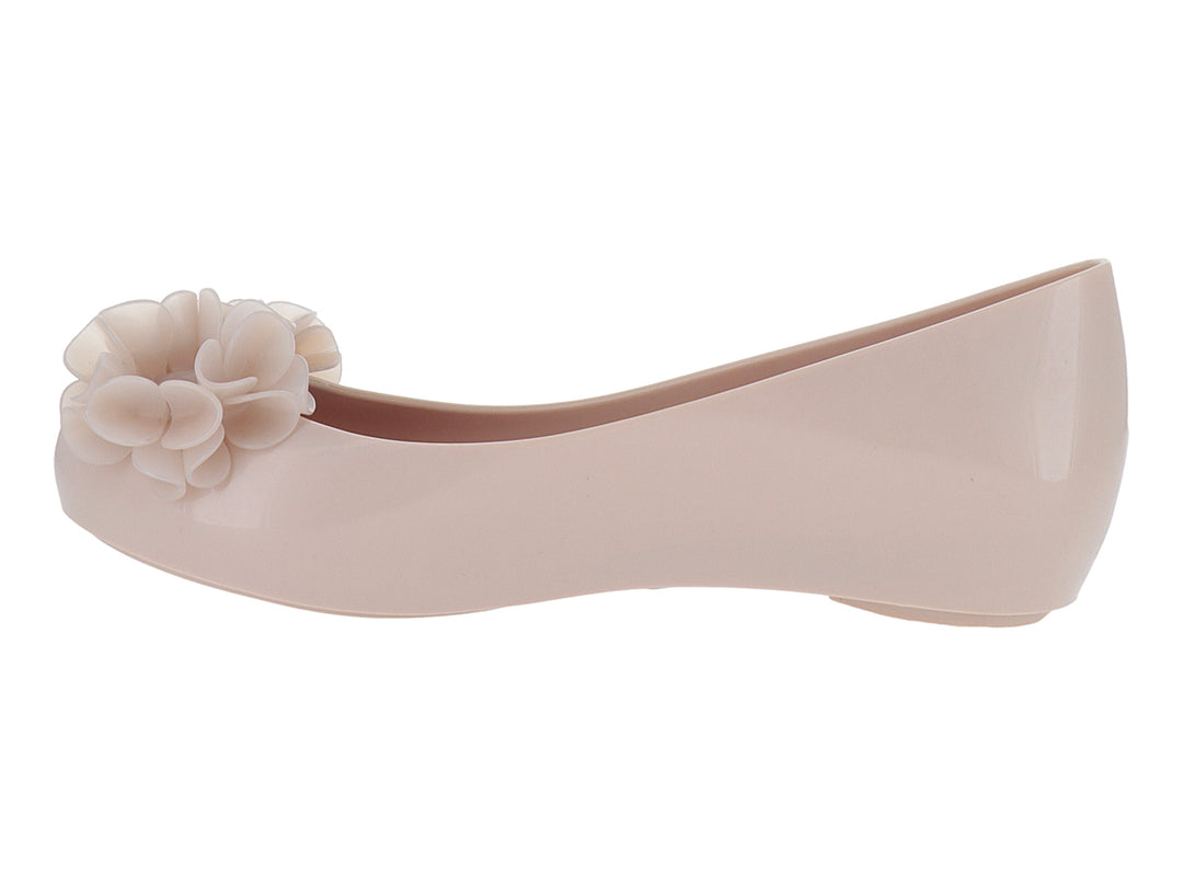 Zapato plano Melissa color rosa con detalle de flor en la punta y acabado brillante.