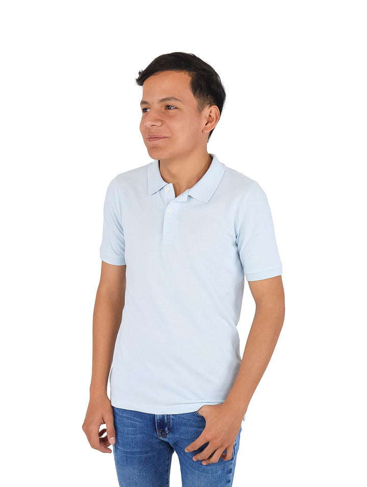 Niño vistiendo una playera polo de color azul cielo y pantalones de mezclilla.