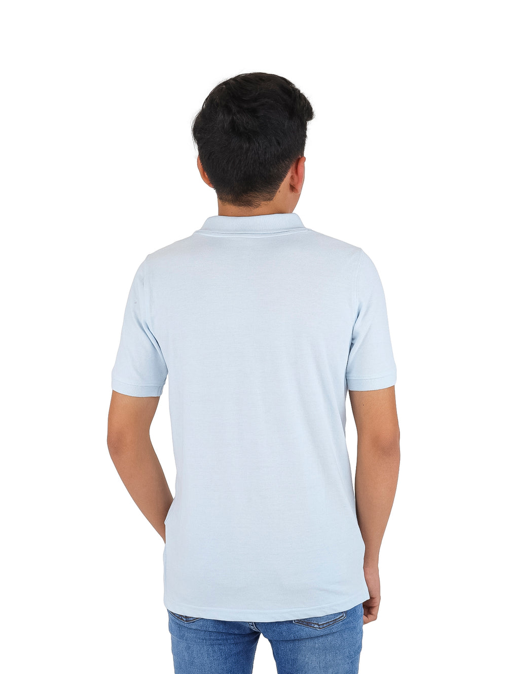 Niño vistiendo una playera polo de color azul cielo y pantalones de mezclilla.