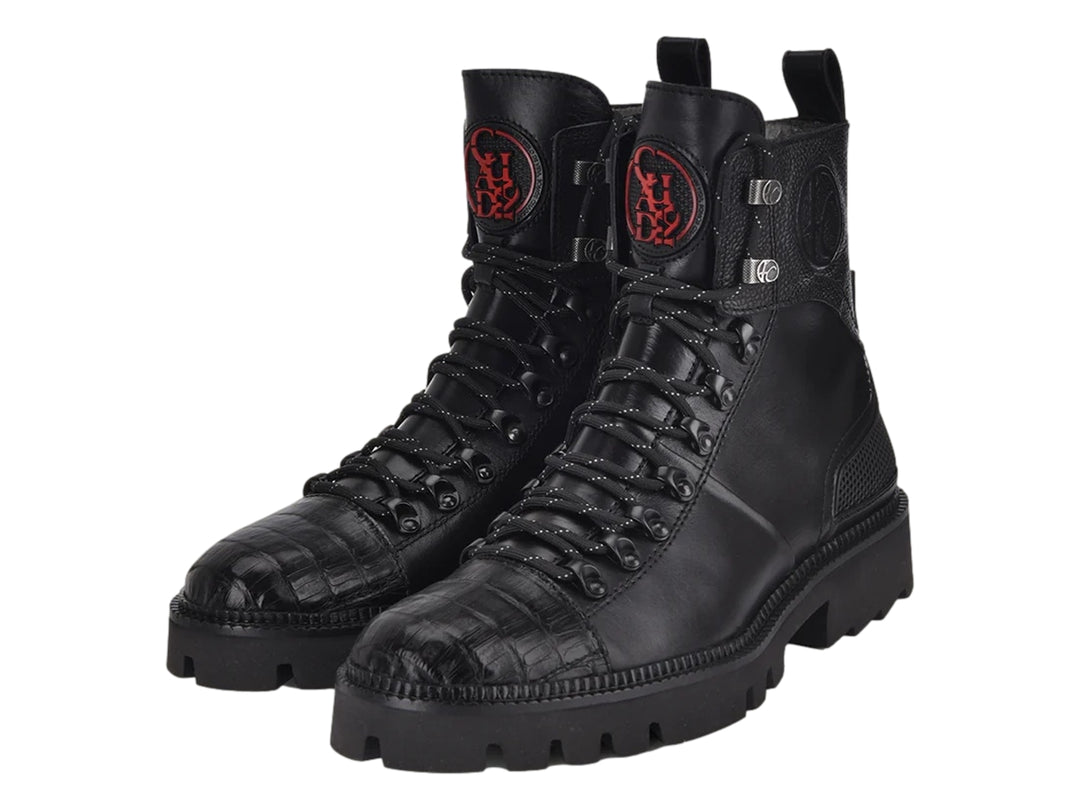 Bota de cuero negro con punta de piel de caimán y suela robusta de goma.