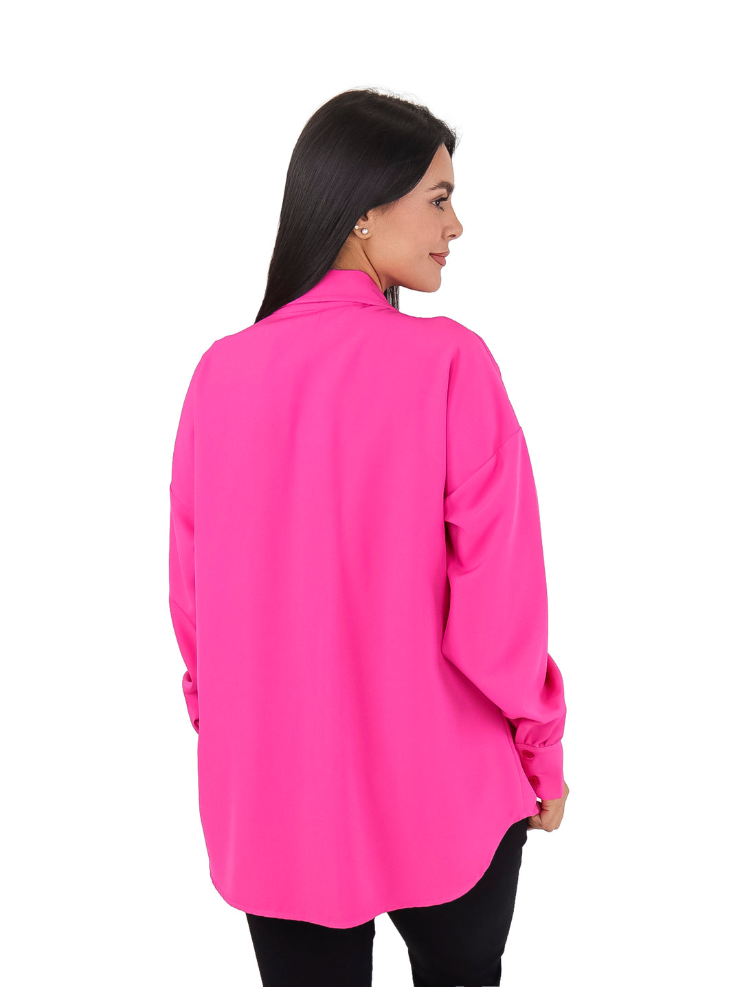 Mujer vistiendo una camisa color fucsia de manga larga con detalles de piedras en los bolsillos frontales.