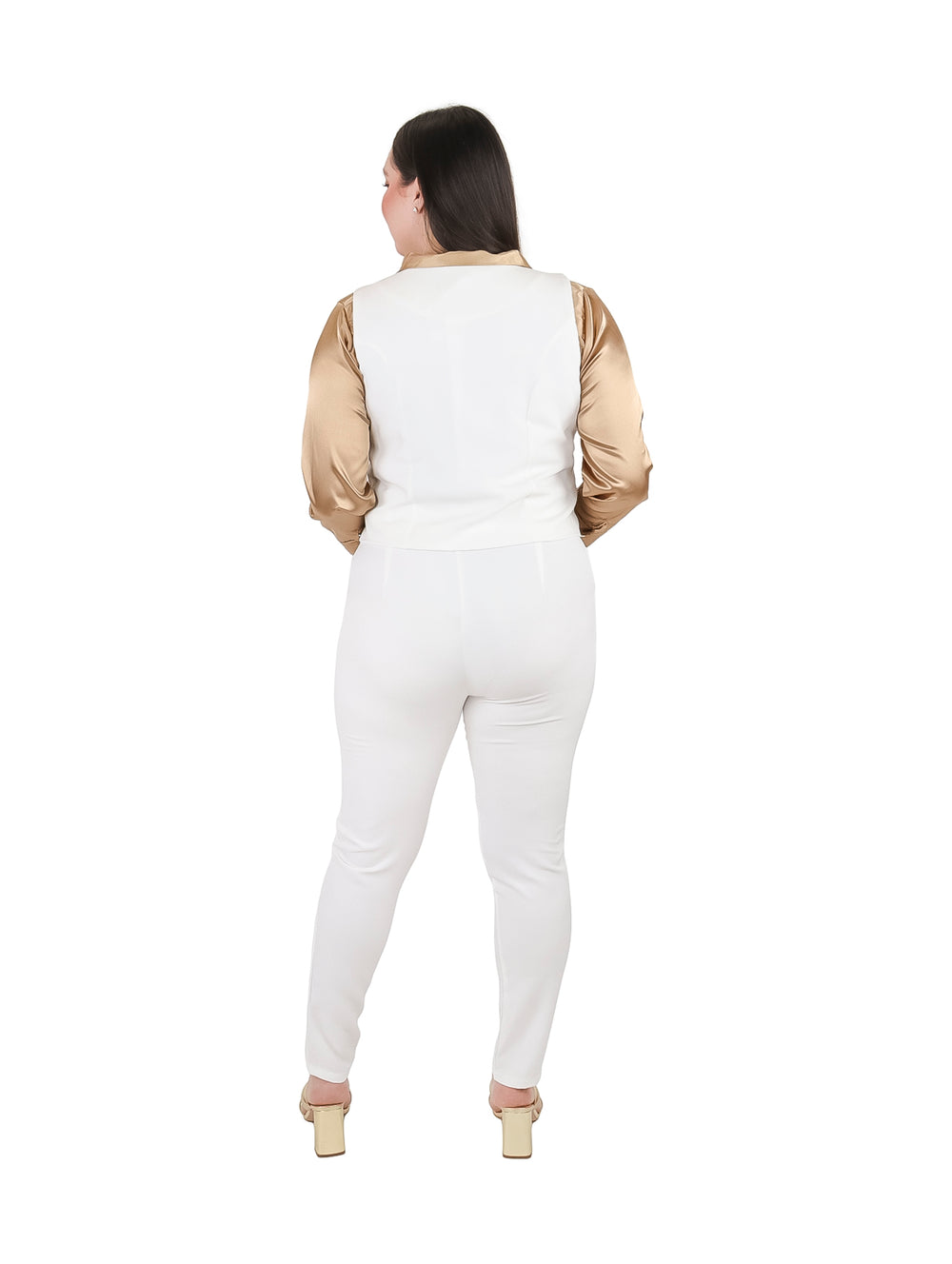Mujer vistiendo conjunto de chaleco y pantalón color ivory con camisa dorada.