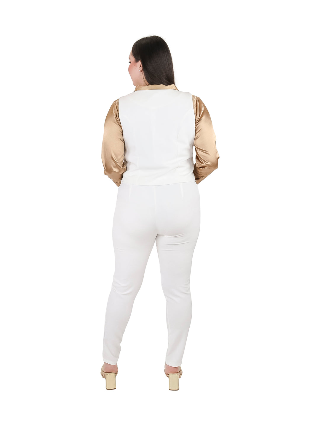 Mujer vistiendo conjunto de chaleco y pantalón color ivory con camisa dorada.