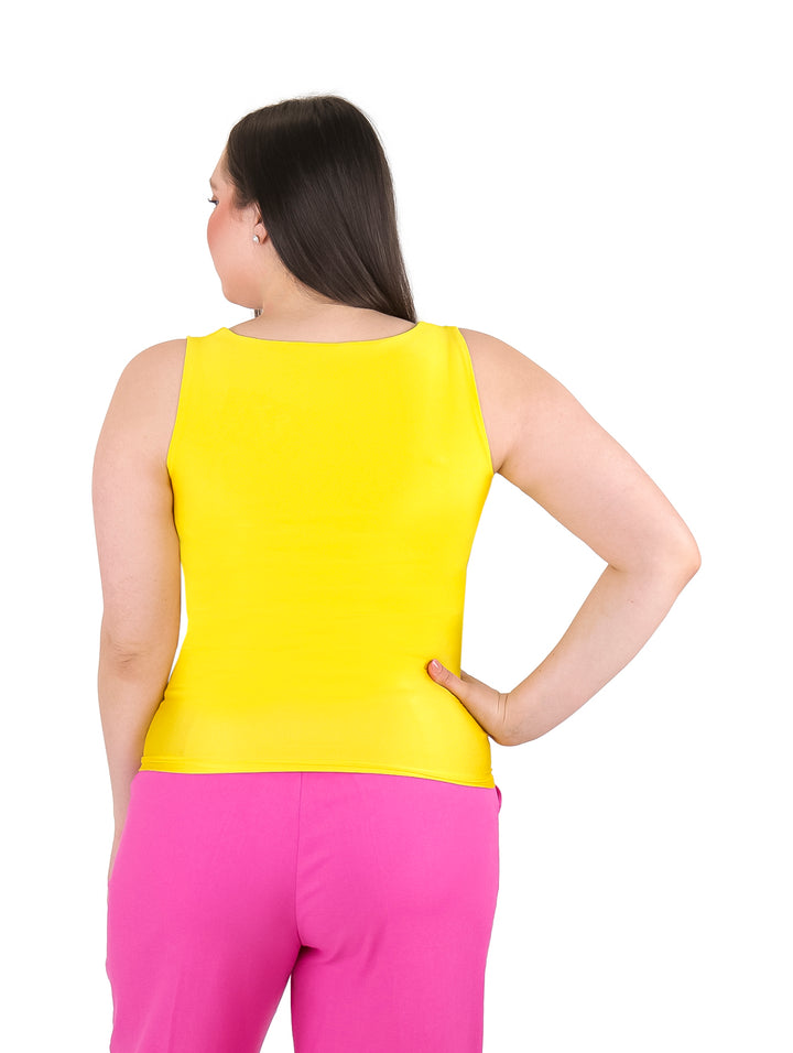Mujer vistiendo una blusa básica amarilla sin mangas y cuello redondo.