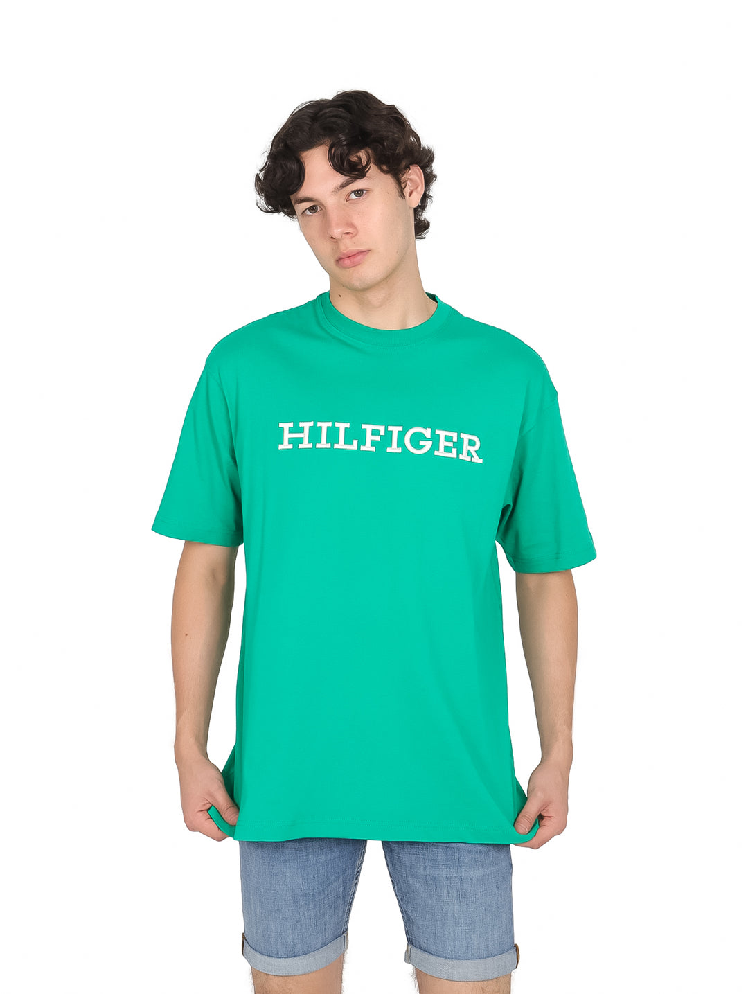 Hombre vistiendo camiseta manga corta color verde con texto HILFIGER bordado en blanco en el pecho.
