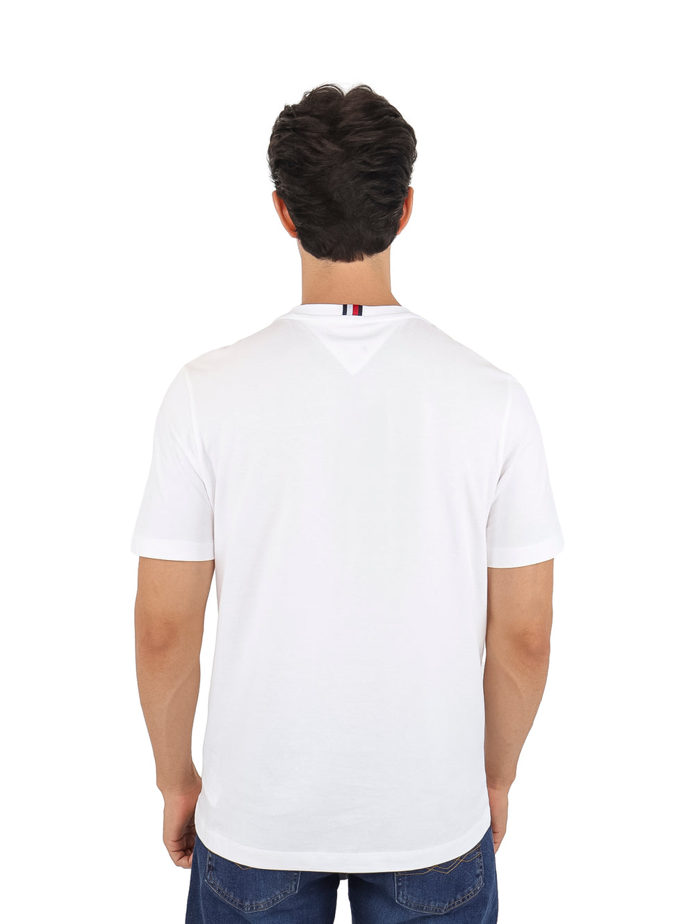 Hombre vistiendo una camiseta Tommy Hilfiger de color blanco con un estampado rectangular en el pecho.
