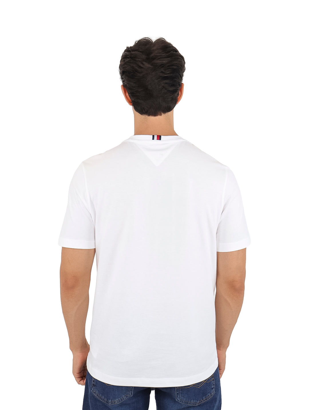Hombre vistiendo una camiseta Tommy Hilfiger de color blanco con un estampado rectangular en el pecho.