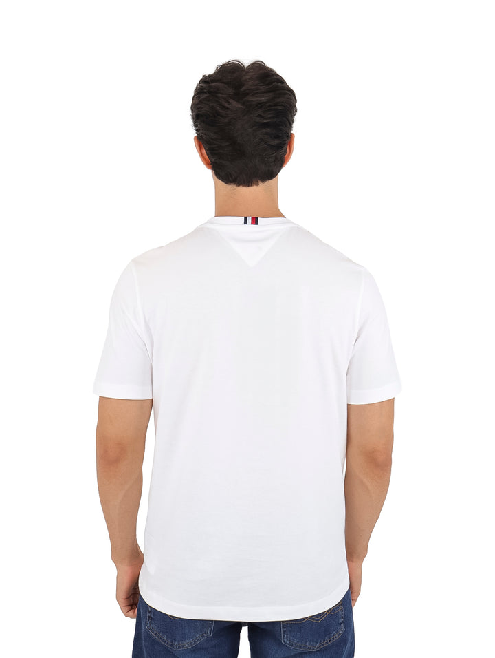 Hombre vistiendo una camiseta Tommy Hilfiger de color blanco con un estampado rectangular en el pecho.