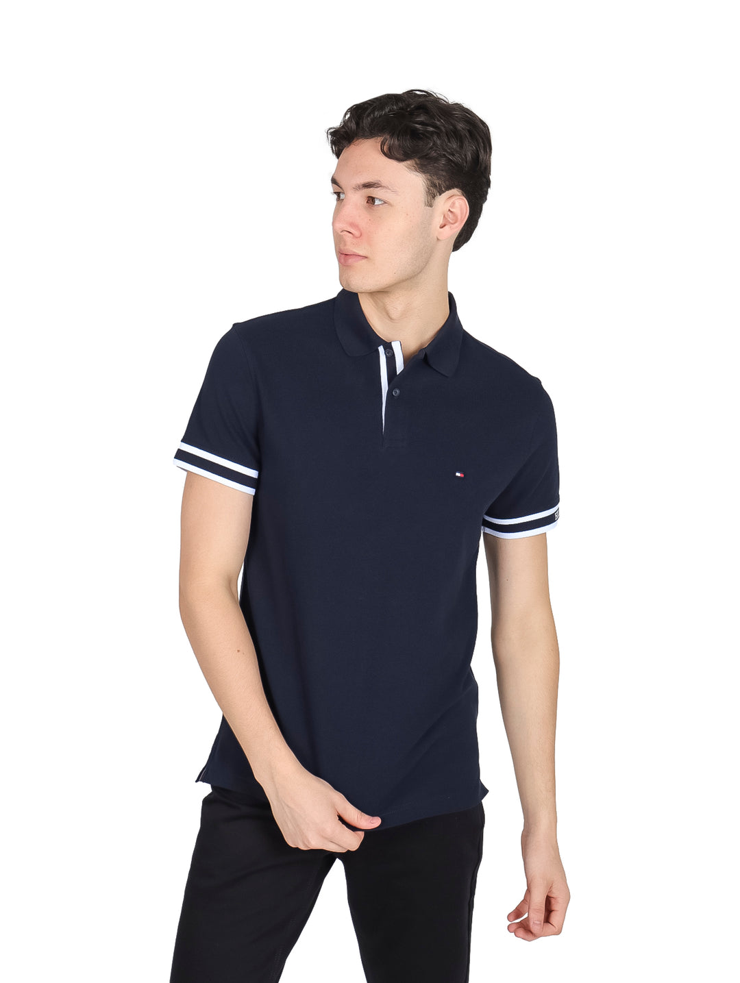 Hombre vistiendo polo Tommy Hilfiger color azul marino con franjas blancas en los puños.