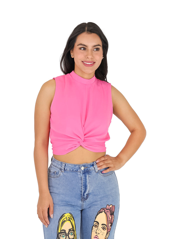 Mujer vistiendo una blusa rosa corta sin mangas con detalle de nudo en la cintura y cuello alto.