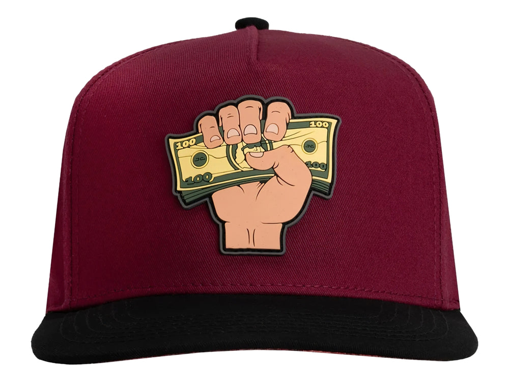 Gorra snapback color rojo con visera negra y un parche frontal de una mano sosteniendo billetes.
