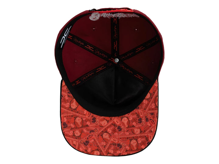 Gorra snapback color rojo con visera negra y un parche frontal de una mano sosteniendo billetes.