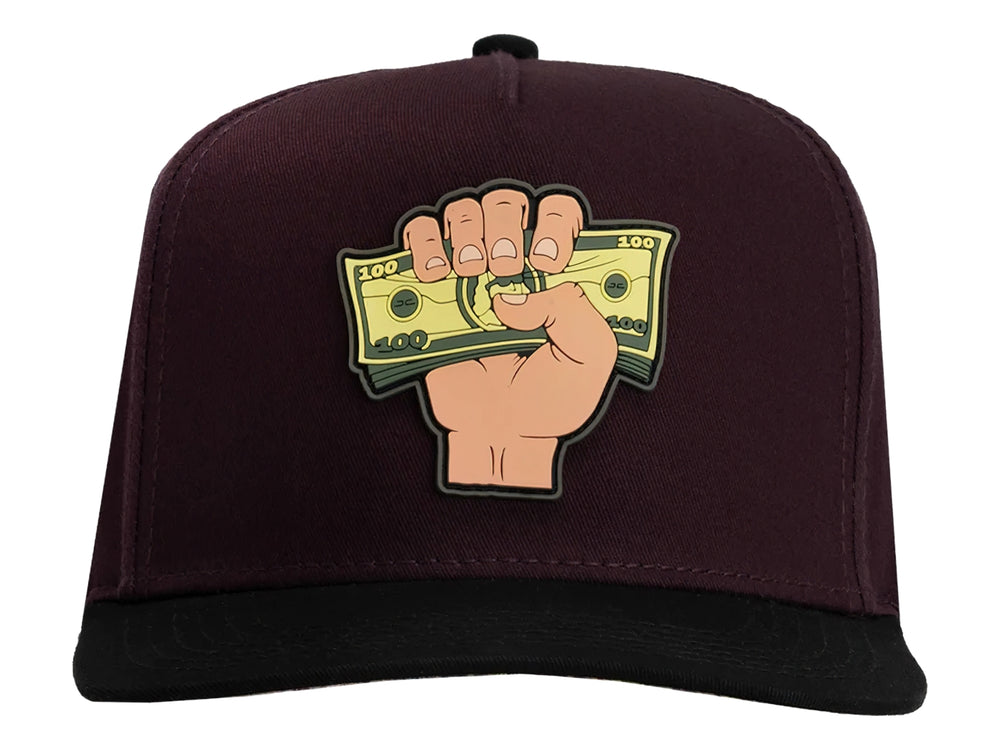Gorra snapback color burgundy con visera negra y un parche frontal de una mano sosteniendo billetes.
