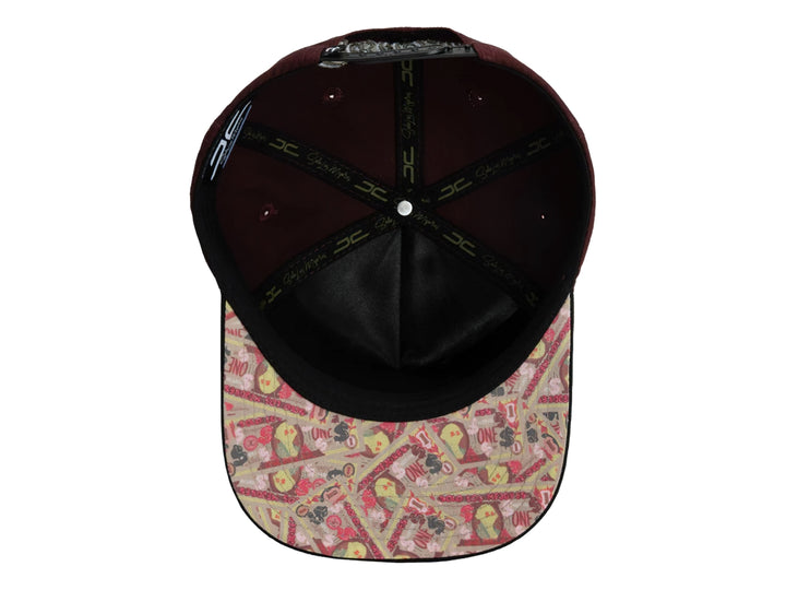 Gorra snapback color burgundy con visera negra y un parche frontal de una mano sosteniendo billetes.