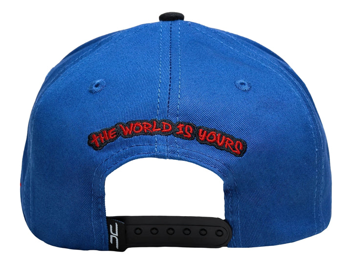 Gorra snapback azul con visera negra, presenta un bordado de rostro en el frente y logo lateral rojo.