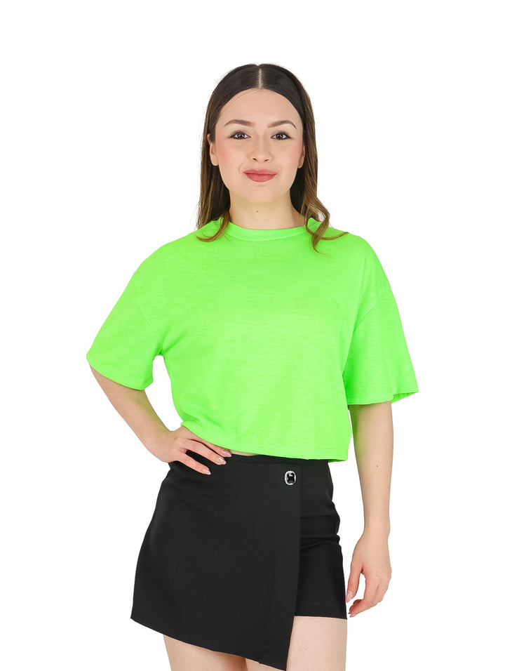 Mujer vistiendo una blusa lisa de color verde neón con mangas cortas y cuello redondo.