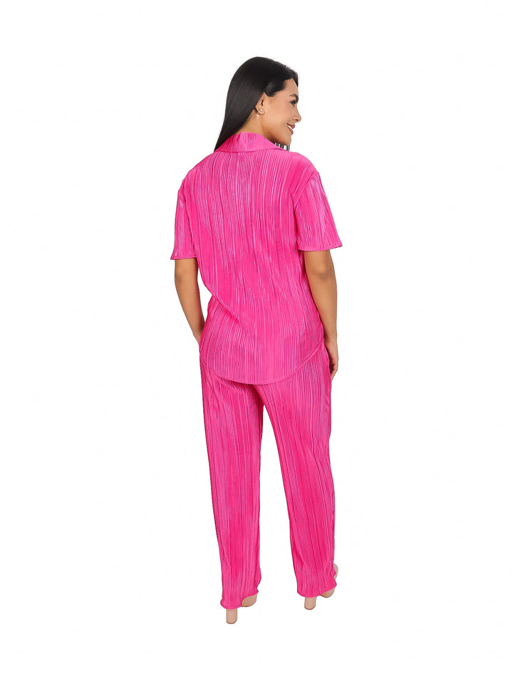 Mujer modelando un conjunto de camisa y pantalón color fucsia con textura de líneas verticales.