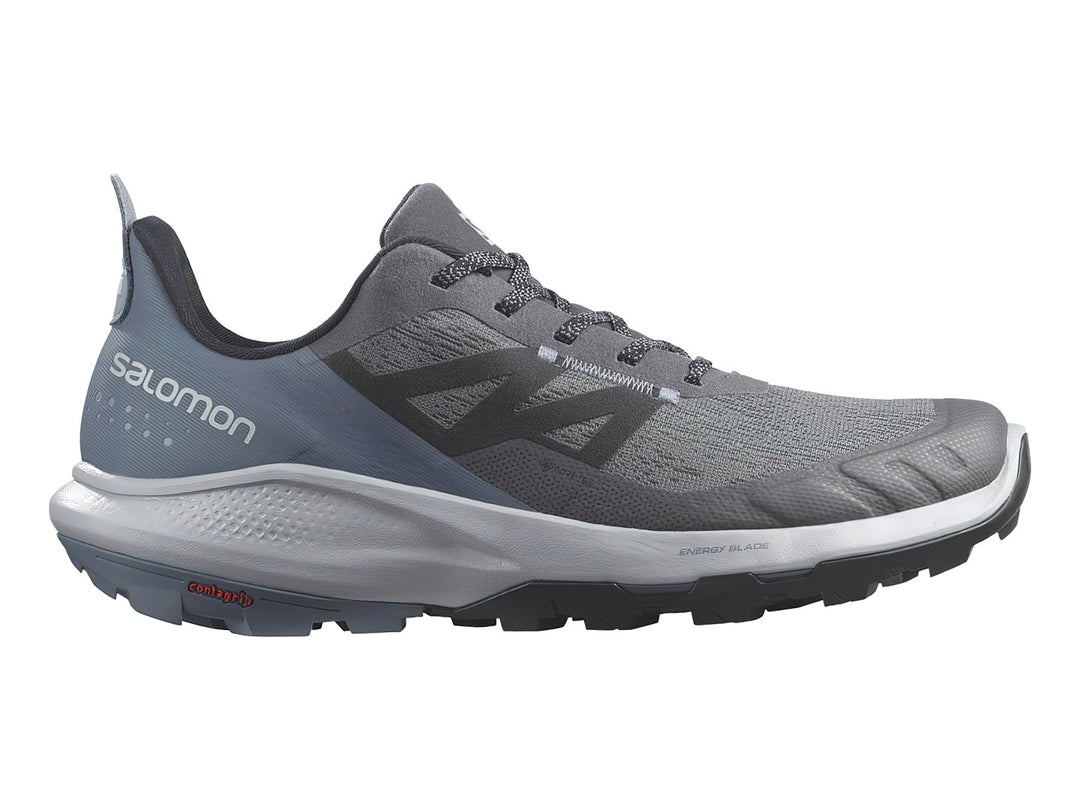 Tenis deportivos Salomon en tonos gris y azul con suela blanca y negra.