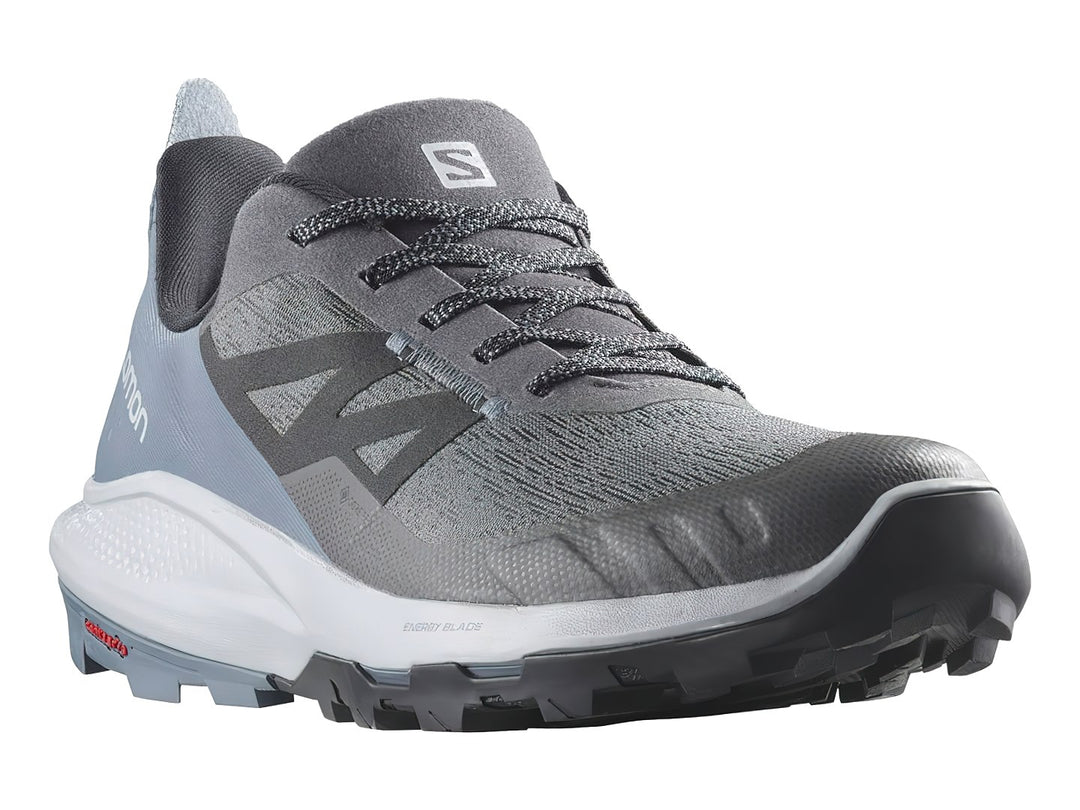 Tenis deportivos Salomon en tonos gris y azul con suela blanca y negra.