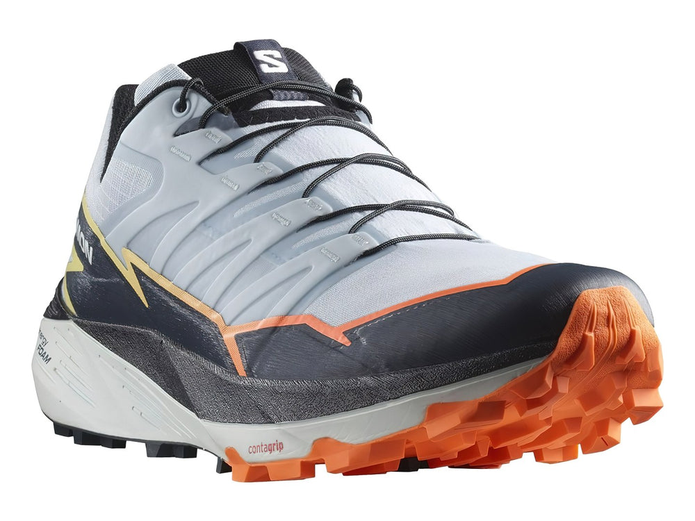 Tenis Salomon Thundercross color blanco y gris con detalles en naranja y suela para trail.