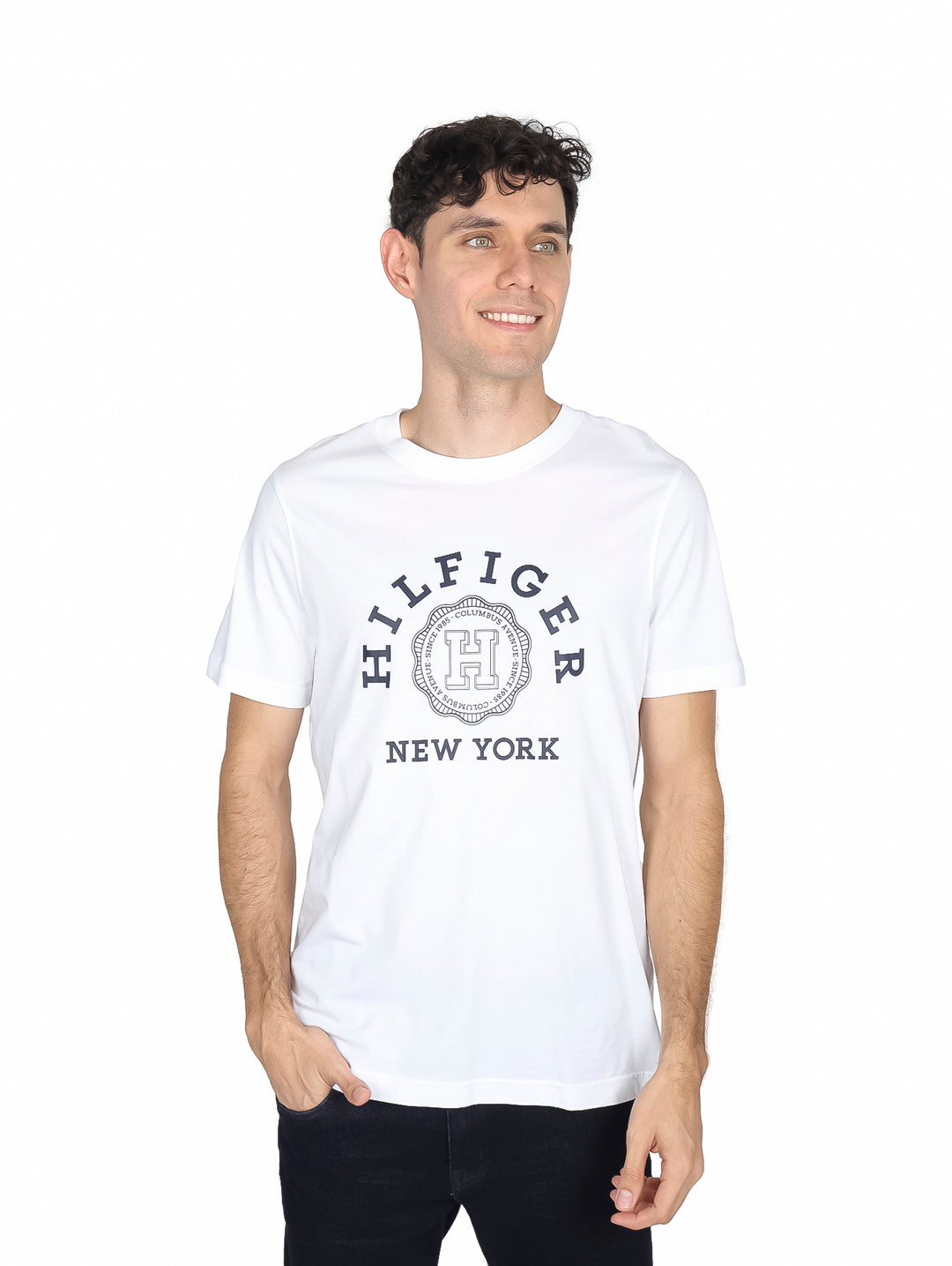 Hombre vistiendo camiseta blanca de manga corta con logotipo de Tommy Hilfiger en el pecho.