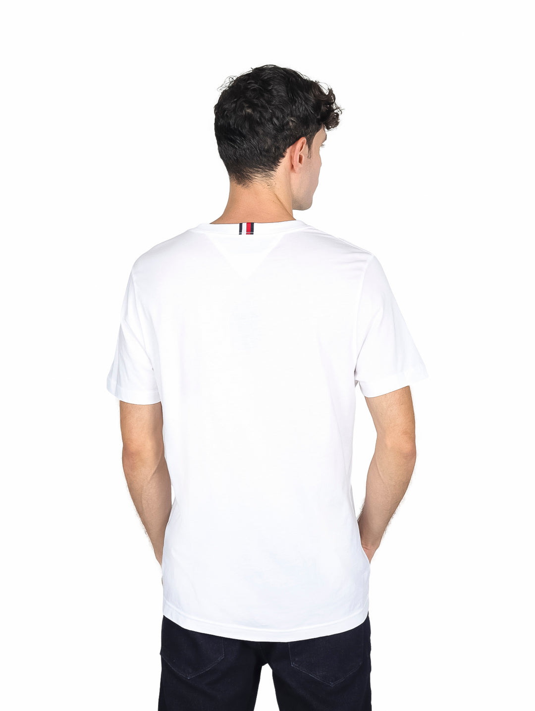 Hombre vistiendo camiseta blanca de manga corta con logotipo de Tommy Hilfiger en el pecho.