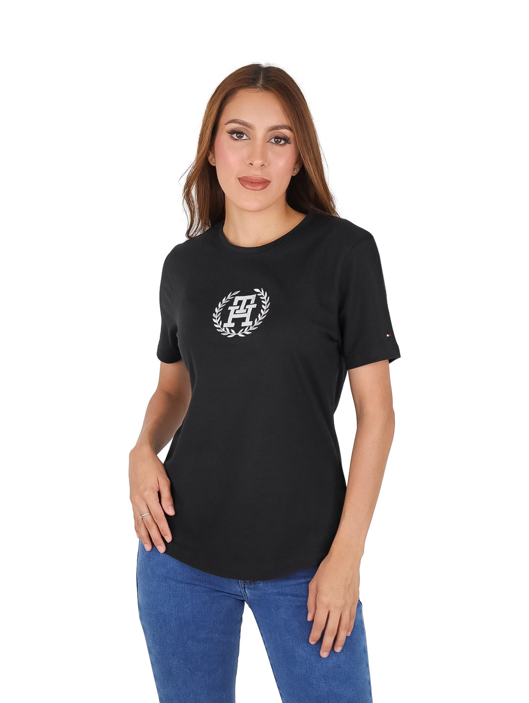 Mujer vistiendo una camiseta negra de manga corta con un logo plateado en el pecho.