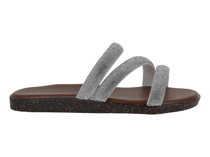 Sandalia plana color plata con tiras brillantes y suela marrón.