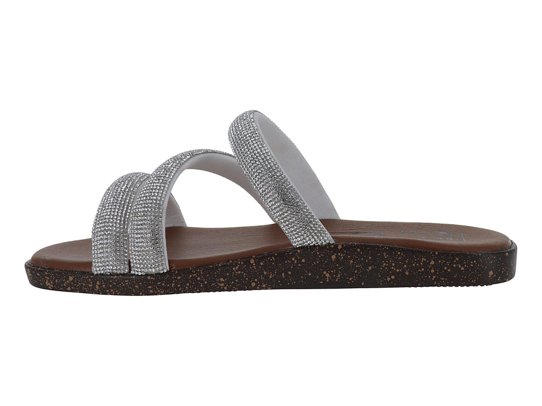 Sandalia plana color plata con tiras brillantes y suela marrón.